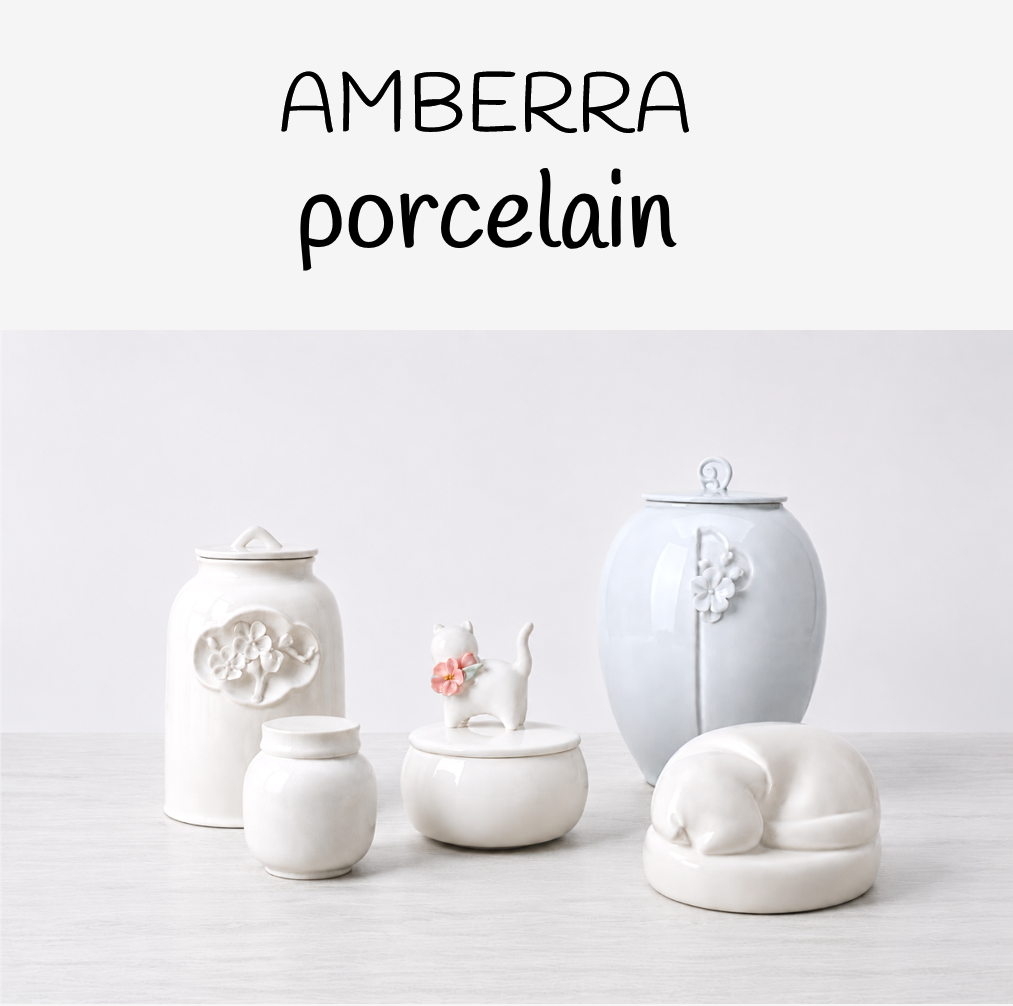 Collection of white ceramic pet urns from Amberra Porcelain collection on white background 