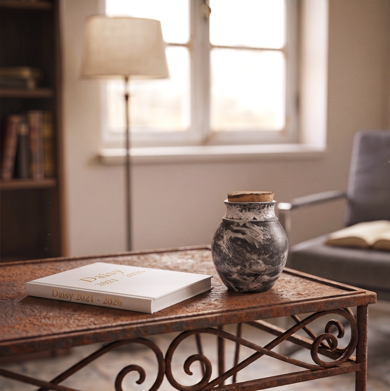 Ceramic charcoal black and white ash urn on rustic table in reading room