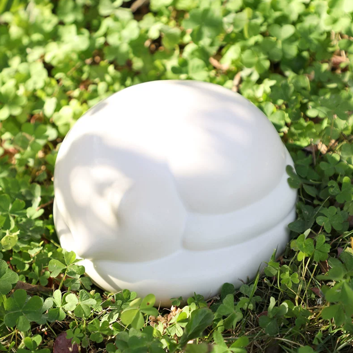 Satin white porcelain ceramic urn sculpture of a sleeping cat