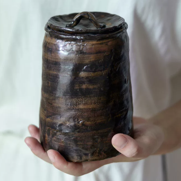 Glazed brown-bronze-black artisanal pet urn with organic shape and color patterns
