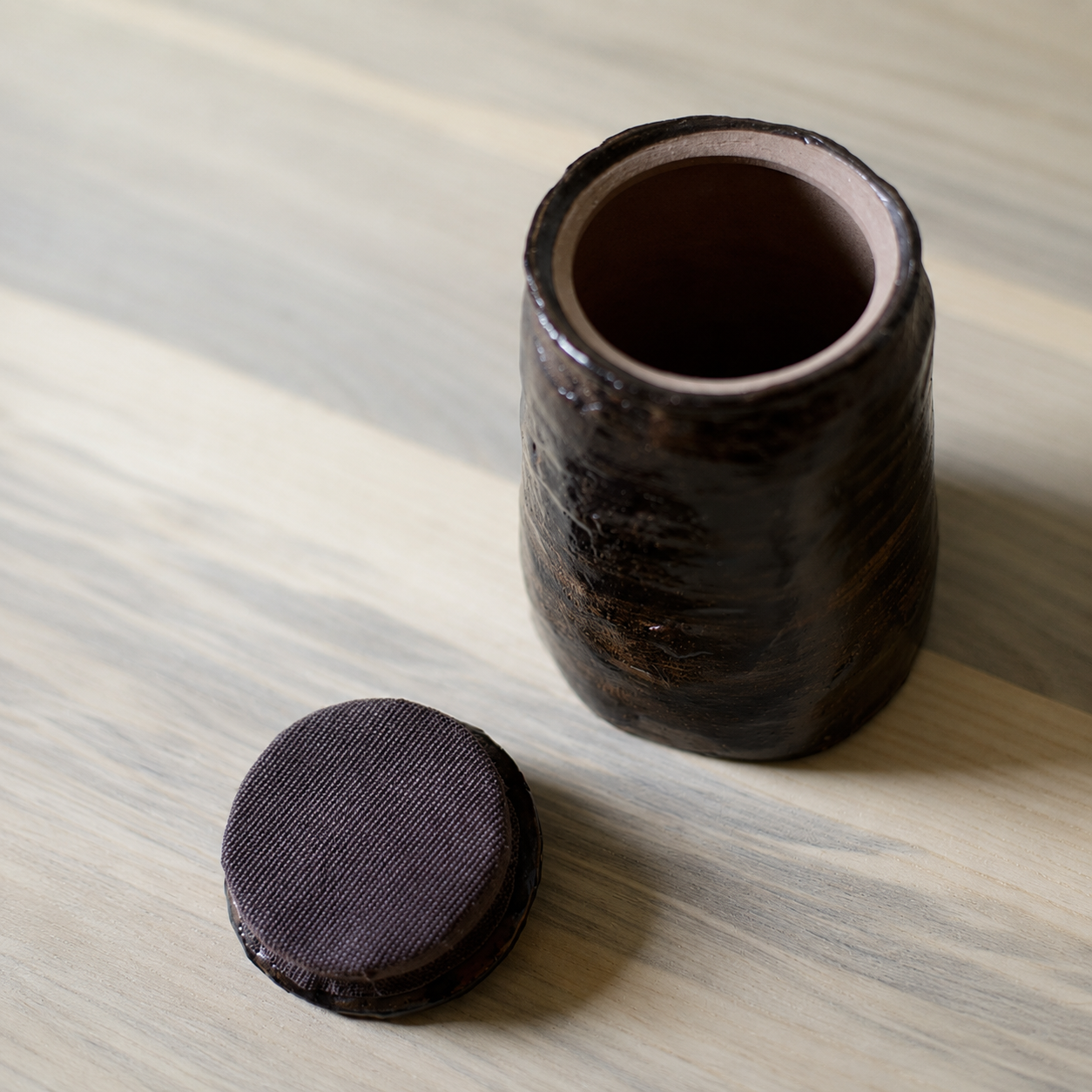 Glazed brown-bronze-black artisanal pet urn with open lid