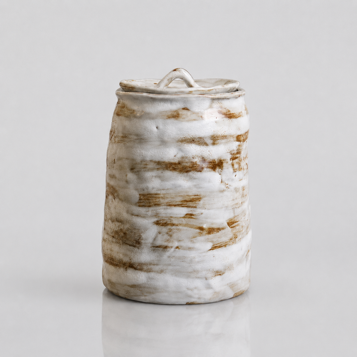 Glazed white brown artisanal pet urn with organic shape and color patterns